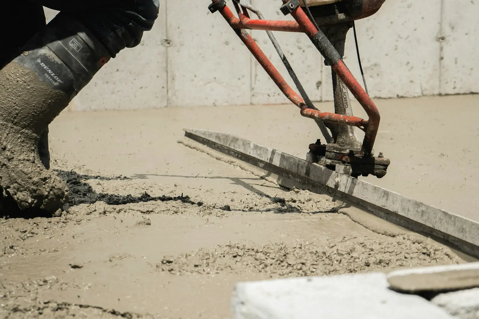 Finisher working a bull float across wet concrete on a Troy, MI flatwork pour